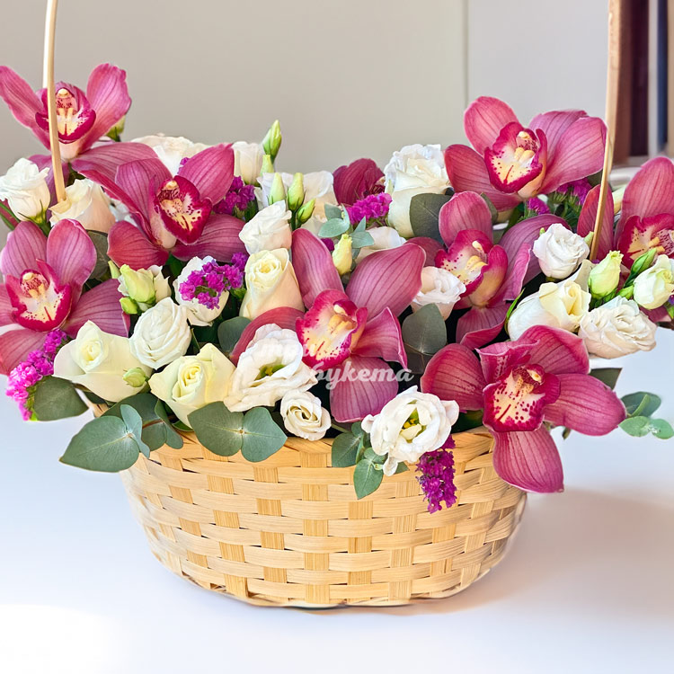 Орхидеи с розами и эустомами в корзине (крупный план)